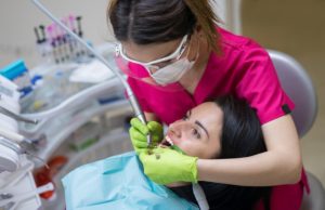 dentist cleaning teeth of woman