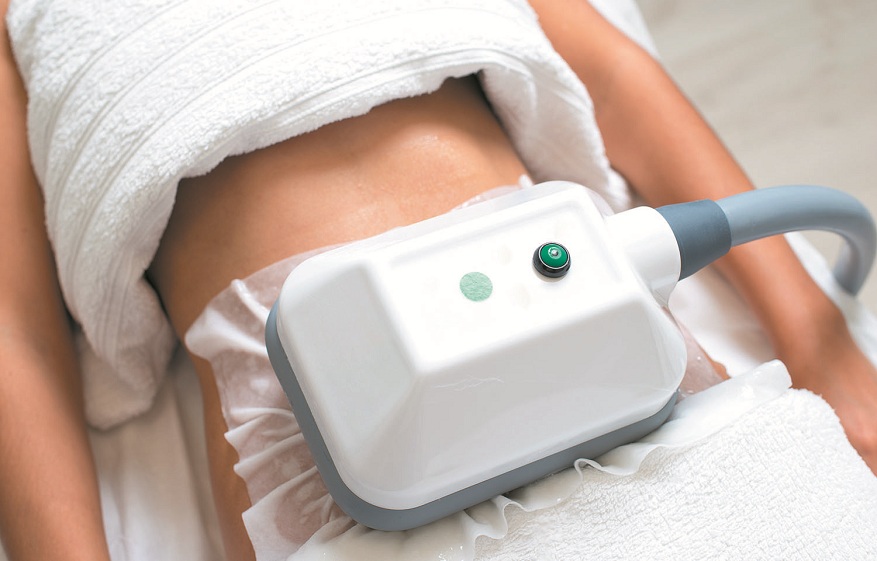 young woman getting cryolipolyse treatment in cosmetic cabinet